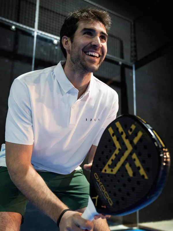 A professional padel player smiling on court