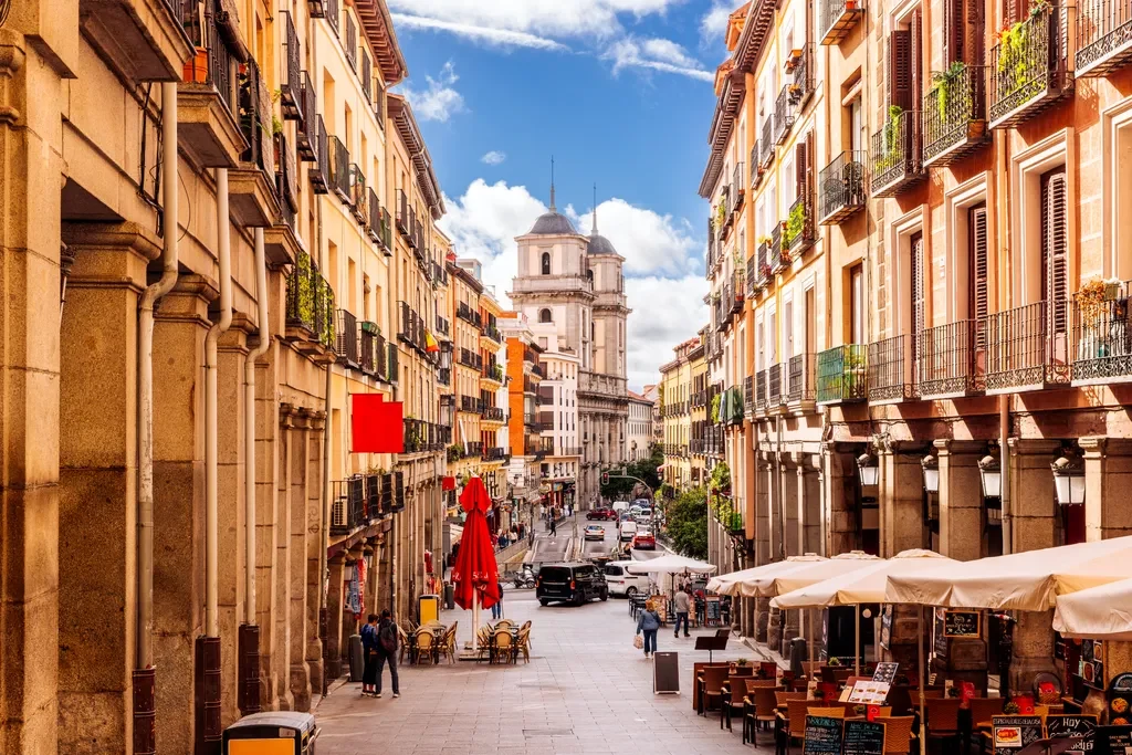 Historic Madrid street with pavement cafés and warm stone façades